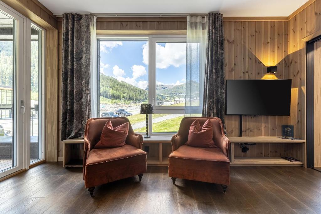 a living room with two chairs and a television at Hemsedal - Fyri Resort - Leiligheter in Hemsedal