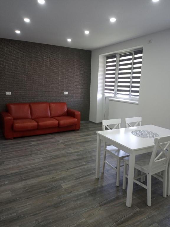 - un salon avec un canapé, une table et des chaises dans l'établissement New Apartment, à Petroşani