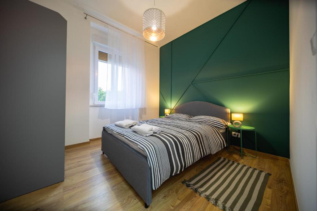 um quarto com uma cama com uma parede verde em Brunea em Rijeka