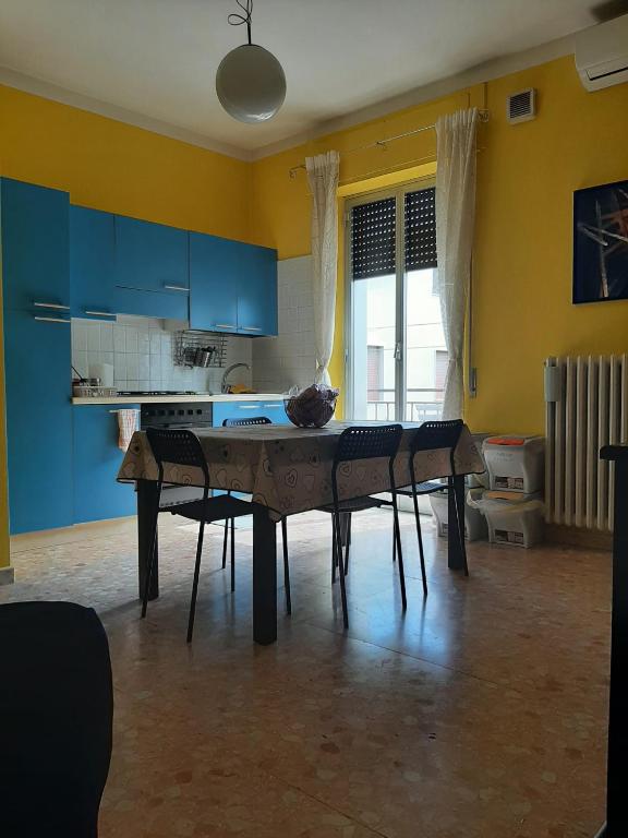 kuchnia z niebieskimi szafkami oraz stołem i krzesłami w obiekcie Casa vacanze Omero 2 w mieście San Salvo