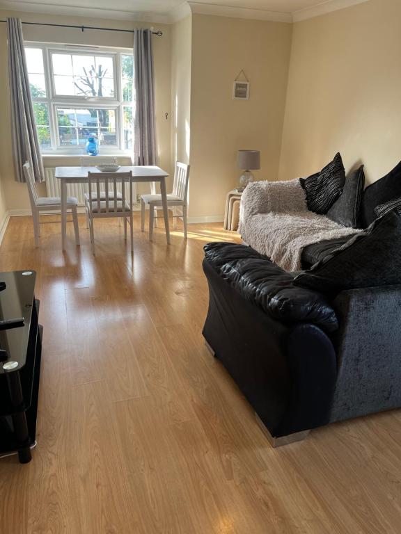 a living room with a couch and a table at Lovely Two bed flat located in the heart of Dunstable in Dunstable