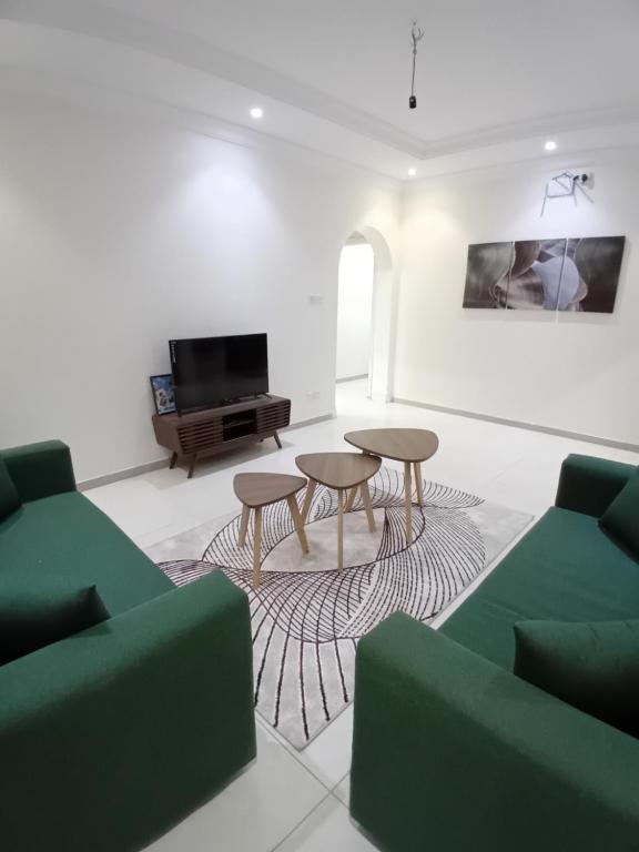 a living room with two tables and a tv at وحدة الأنس 11 in Al Madinah