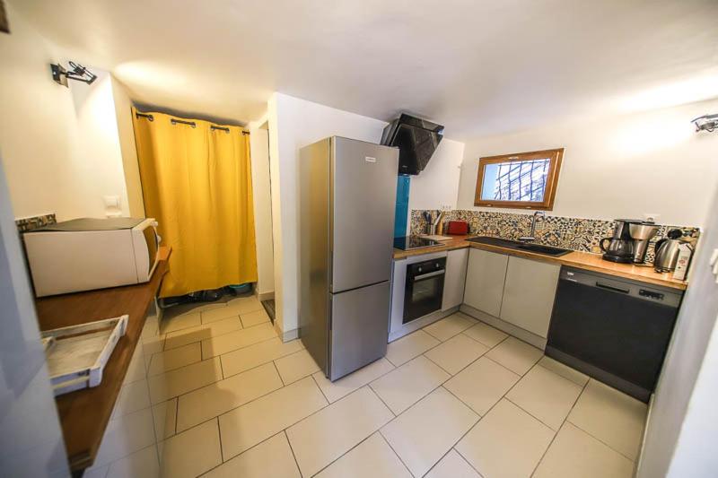 a kitchen with a stainless steel refrigerator in a room at Beau T2 au pied de Montdauphin in Eygliers