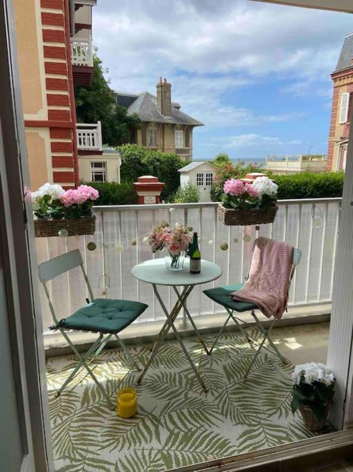 un patio avec deux chaises et une table sur un balcon dans l'établissement JOLI STUDIO VUE MER , plage au bout de la rue !, à Villers-sur-Mer