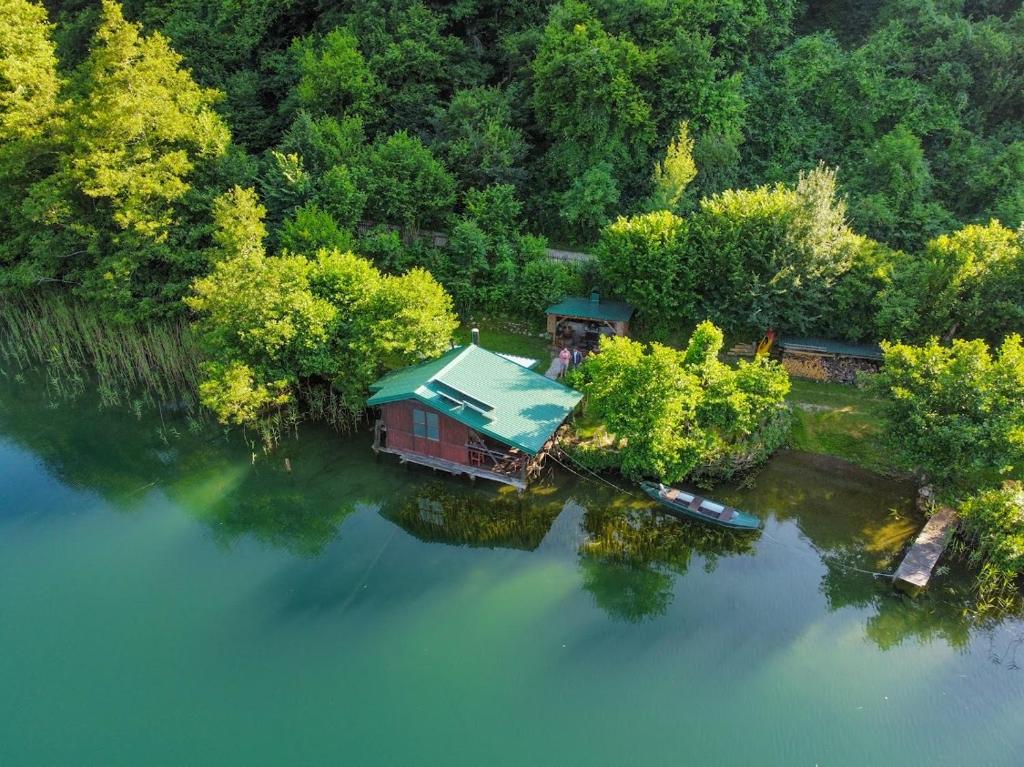 een luchtzicht op een huis op een eiland in het water bij ECO cabin Plivsko jezero Jajce in Jajce
