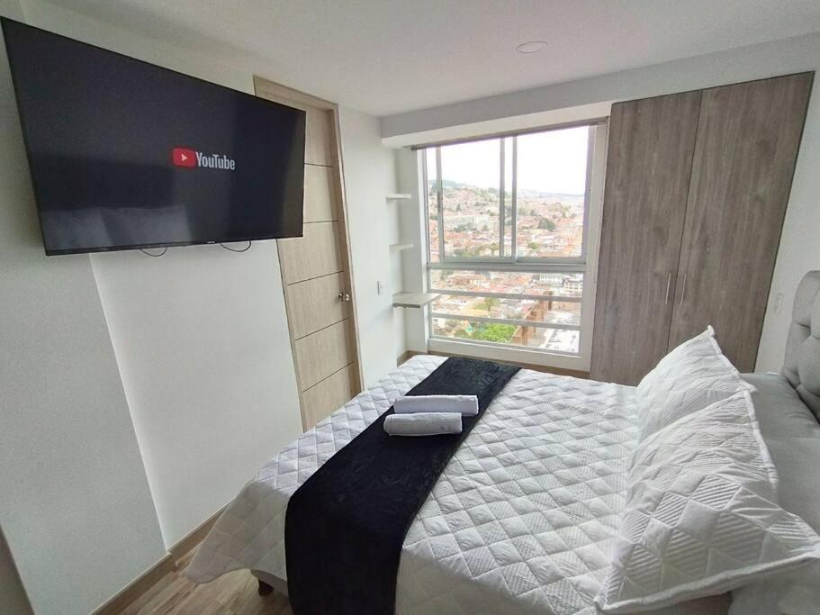 sypialnia z łóżkiem z telewizorem na ścianie w obiekcie Luxury la Candelaria Bogota w mieście Bogota