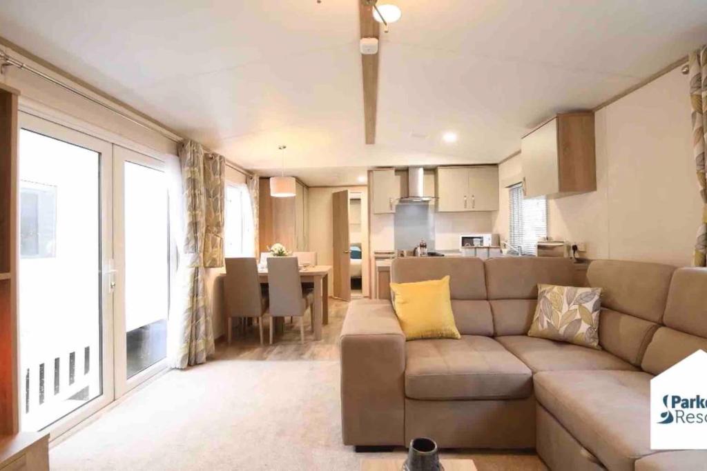 a living room with a couch and a kitchen at Rohannah static Caravan Fantastic Family and Friends Holiday in East Mersea