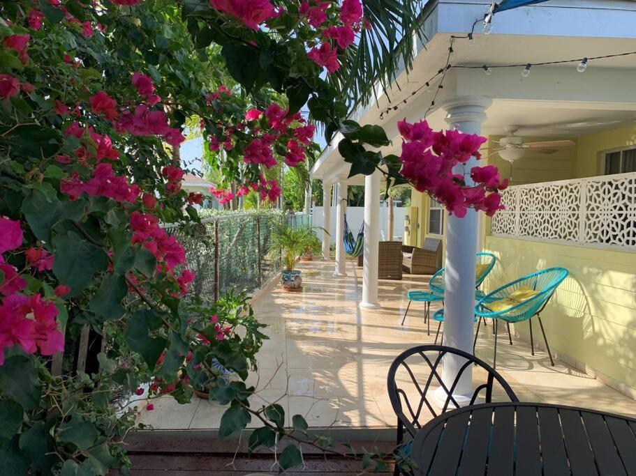 a patio with pink flowers and chairs and a pole at The Diver's Inn Grand Cayman in George Town