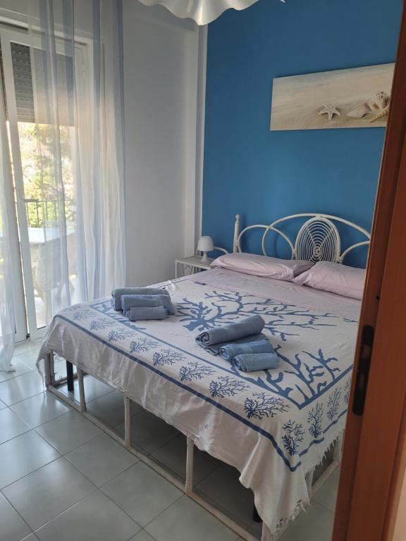 a blue bedroom with a bed with two pillows on it at Bilocale Lungomare Carini in Carini