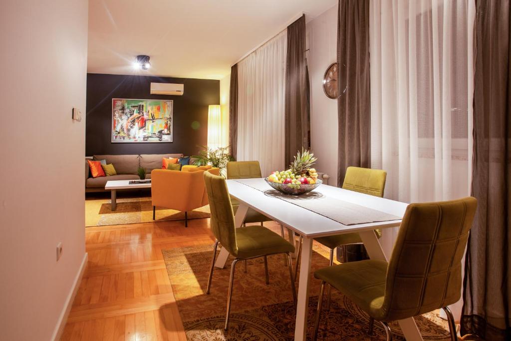 uma sala de jantar com uma mesa e cadeiras e um sofá em Apartment Sladic em Sisak