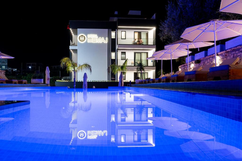 a swimming pool in front of a hotel at night at Hotel Memaj in Ksamil