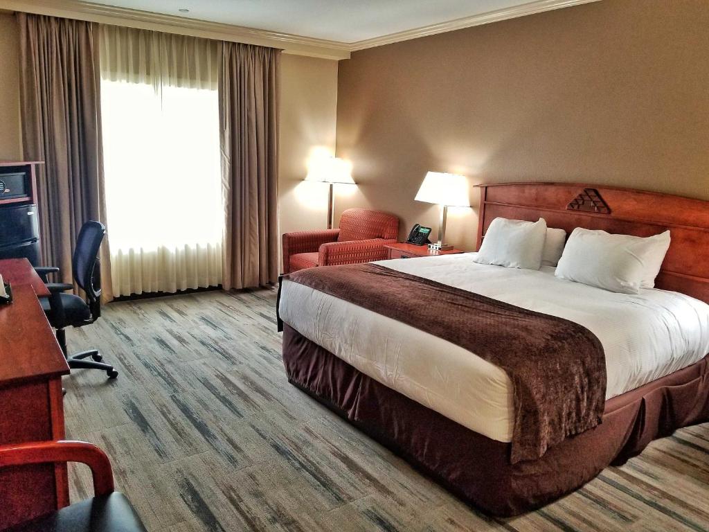 ein Hotelzimmer mit einem großen Bett und einem Schreibtisch in der Unterkunft Lucky 7 Casino & Hotel (Howonquet Lodge) in Smith River