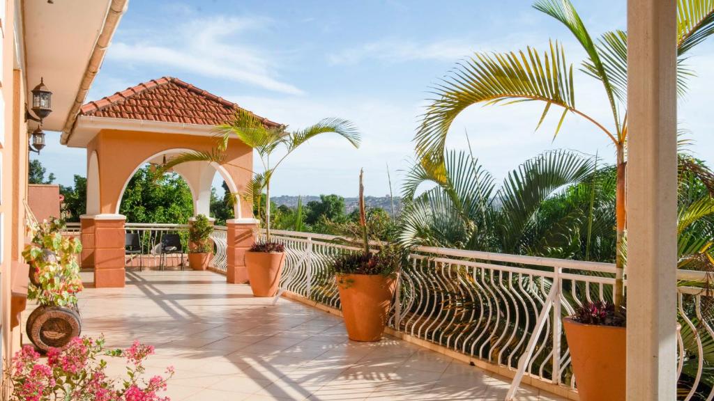 un balcón con macetas y una valla blanca en The Terrace Villa en Kampala