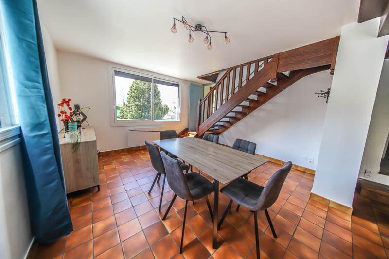 a dining room with a table and chairs and a staircase at Beau T2 au pied de Montdauphin in Eygliers