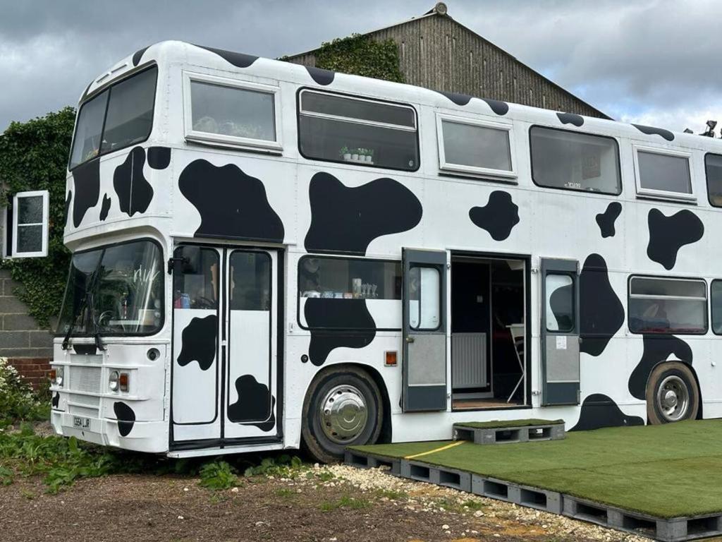 un bus à deux étages avec des vaches peintes sur lui dans l'établissement Mooview- the charming double decker bus, à Norton