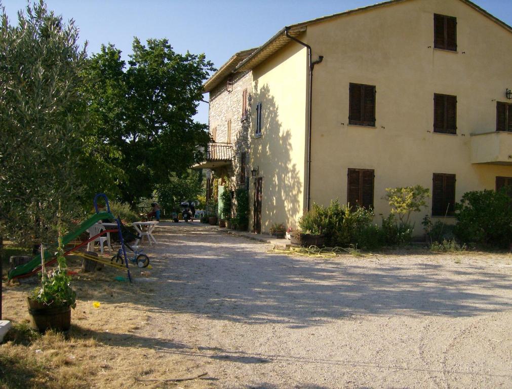 ein großes weißes Gebäude mit einem Baum davor in der Unterkunft B&B Il Sentiero di Assisi in Assisi