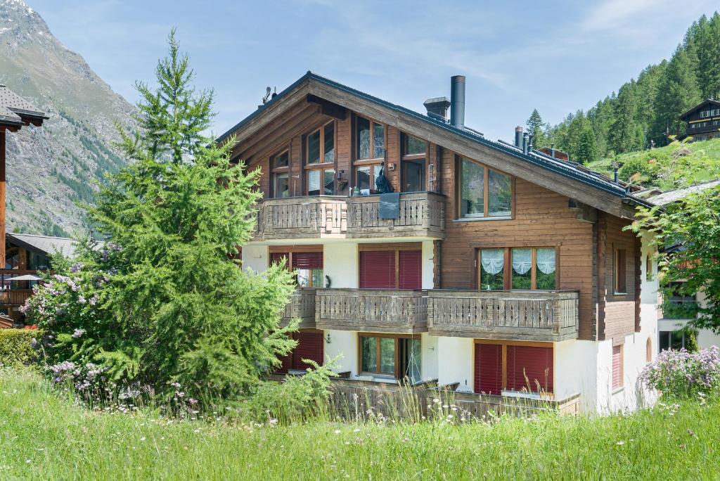 a large wooden house with a balcony at Haus Bärgbach in Zermatt