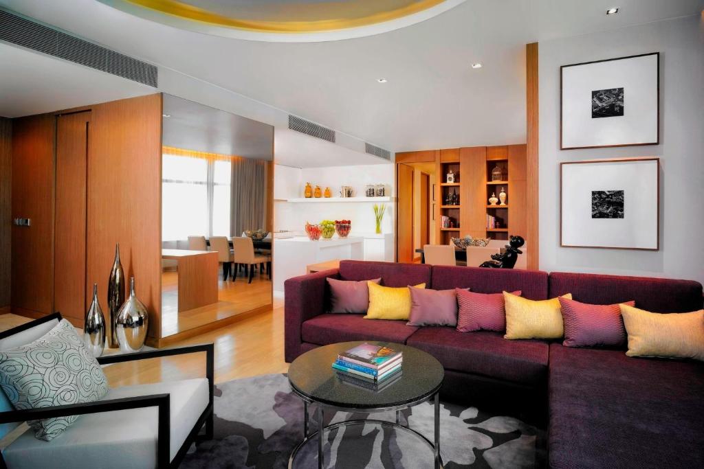 a living room with a purple couch and a table at Marriott Executive Apartments Bangkok, Sukhumvit Thonglor in Bangkok