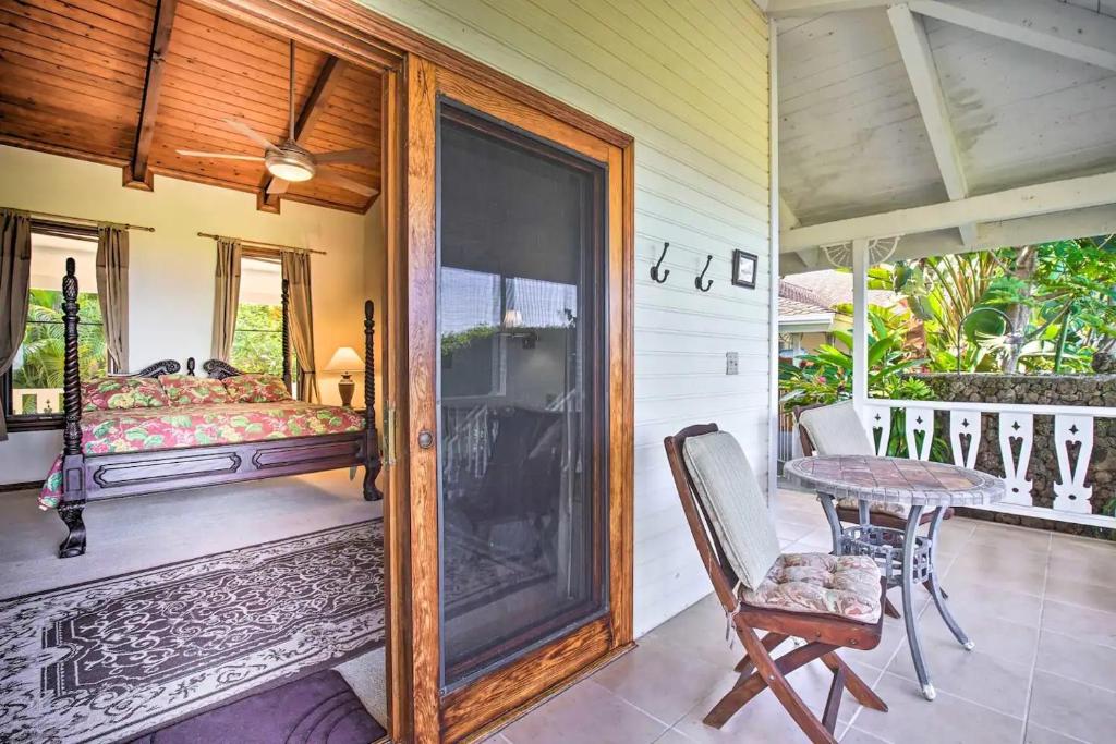 Cette chambre comprend un lit et une table sur une terrasse couverte. dans l'établissement Tranquility Guest House, à Kailua-Kona
