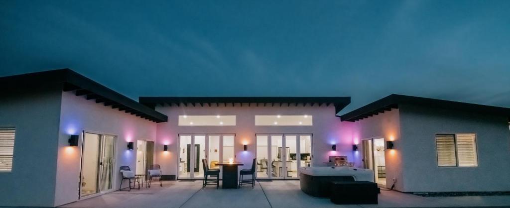 a house with a lit up patio at night at Coyote Tracks - A Modern Desert Experience in Joshua Tree