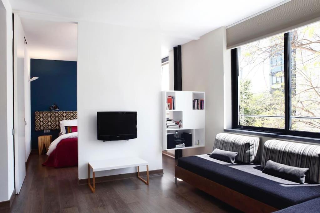 a living room with a couch and a bed at Apartment Vila Olímpica Barcelona next to beach & garden in Barcelona