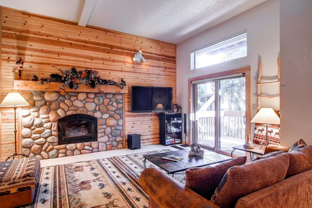 uma sala de estar com uma lareira de pedra e uma televisão em Stunning Multi-Level Home near Hiking Trails and Main St, with PRIVATE Hot Tub WP33 em Breckenridge