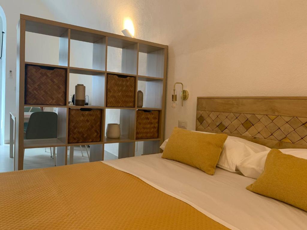 1 dormitorio con cama con almohadas amarillas y escritorio en B&B LA FONTANA, en Mattinata