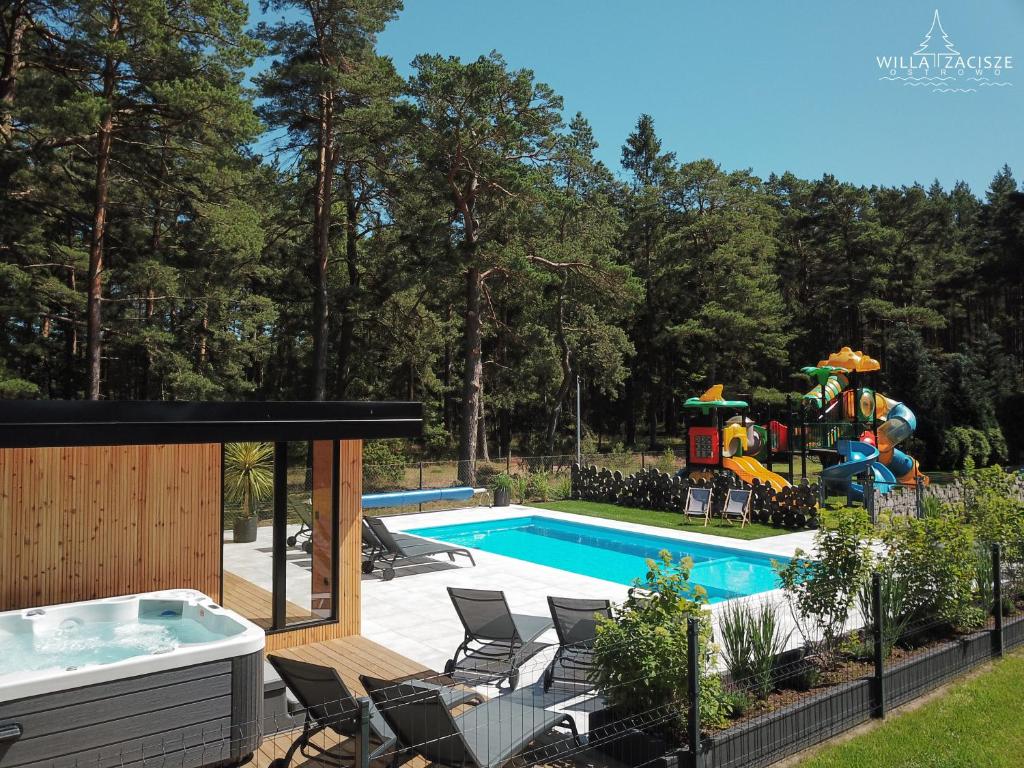 a backyard with a pool and a playground at Willa Zacisze - Ostrowo - Komfortowe Apartamenty i Pokoje w cichej okolicy - Oaza spokoju in Ostrowo