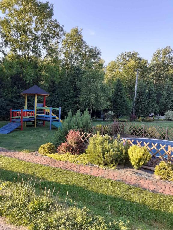 a garden with a playground and a gazebo at Agroturystyka Jagodowa Róża in Mszana Dolna