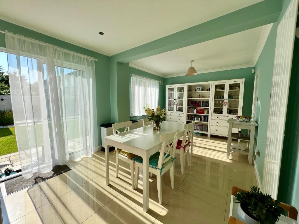 a dining room with green walls and a white table and chairs at Adaline House Dublin in Dublin