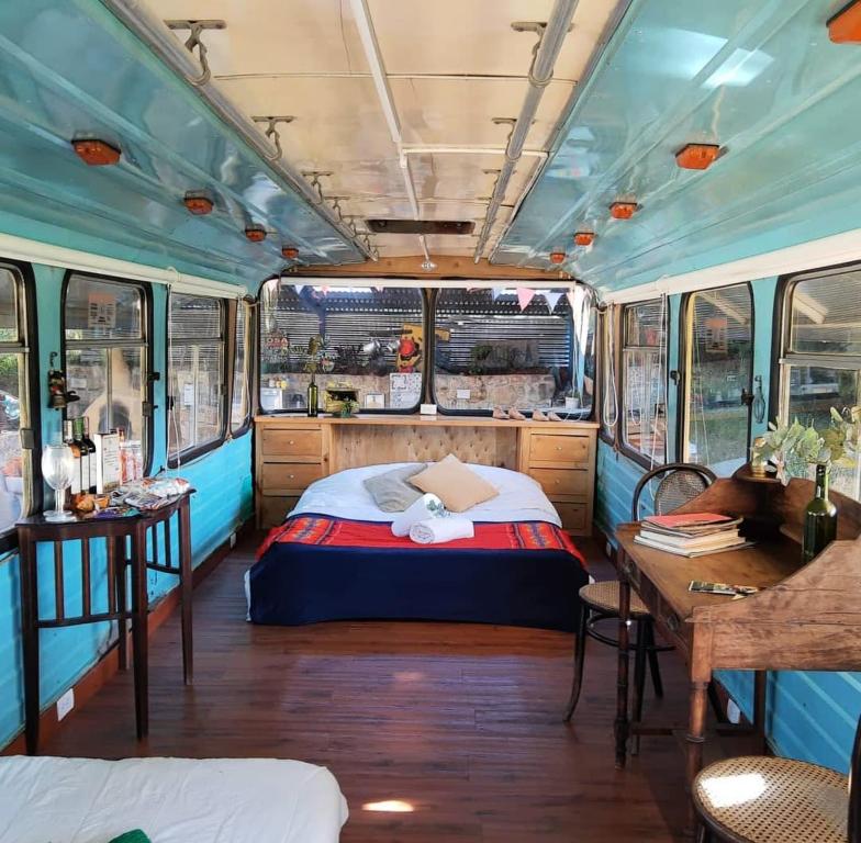 1 dormitorio en un vagón de tren con cama y escritorio en ¡Habitación en un Bus!, en La Calera