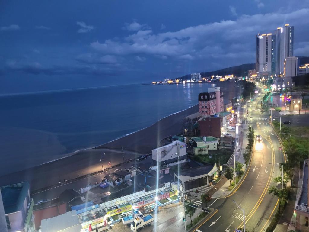 a view of a city at night with the ocean at Blue Ocean House in Ulsan