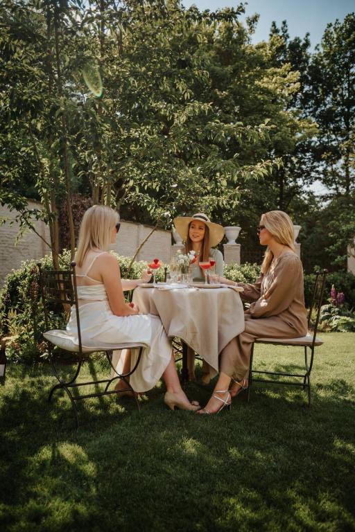 three women sitting at a table in the grass at The Notary in Bruges