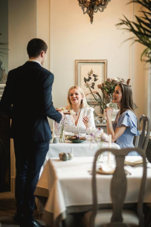 a man and two women sitting at a table at The Notary in Bruges