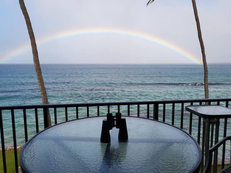 ラハイナにあるThe Noniluna Two - Sleeps 8 plus Pack N Playの海の上に虹が見えるバルコニーのテーブル