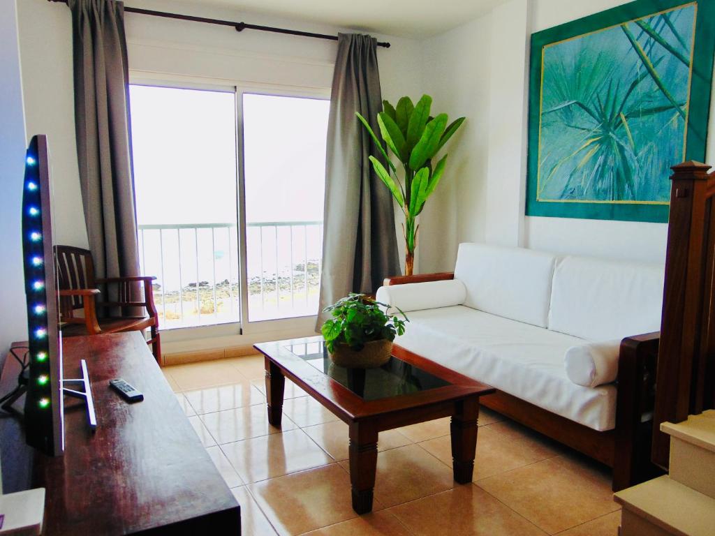 een woonkamer met een witte bank en een salontafel bij Vista al Mar Fuerteventura in Puerto del Rosario