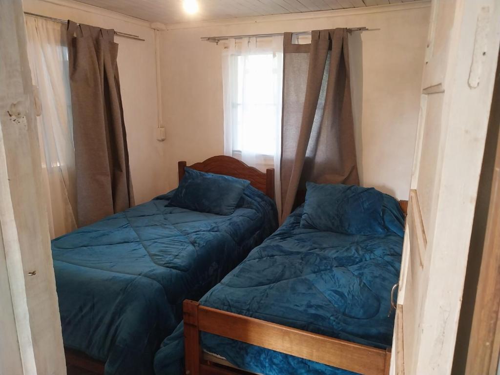 1 dormitorio con 2 camas y ventana en Mary, en Curicó
