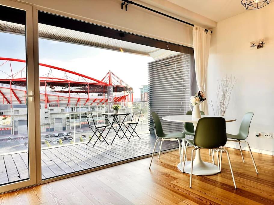 Habitación con mesa, sillas y ventana grande. en Luz Benfica Apartment en Lisboa