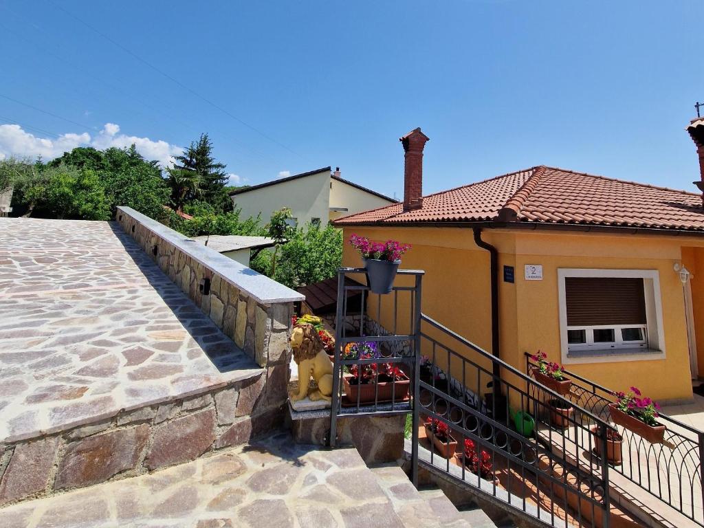 Una casa amarilla con una boca de incendios en un balcón. en Apartments with parking space Matulji, Opatija - 21458, en Matulji