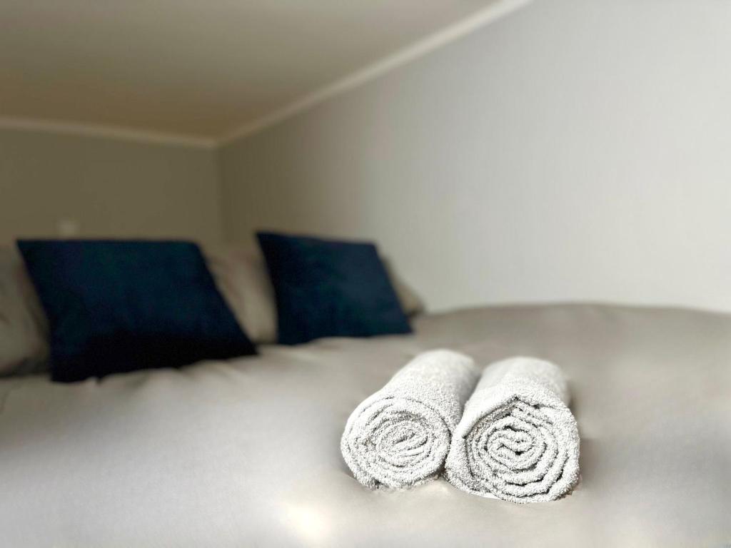 two rolled towels sitting on top of a bed at MMRent Lazy Room in Gdańsk