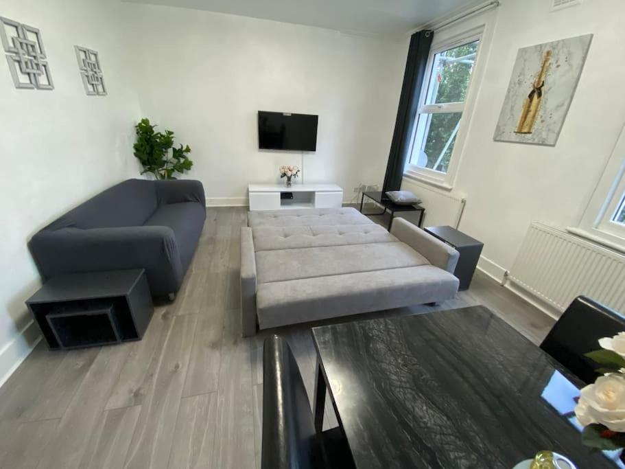 a living room with a couch and a tv at 2 Bedroom Flat in London in London