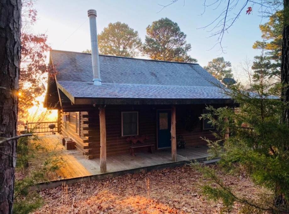 a log cabin with a porch in the woods at Chalet with a view at Bear Mountain - Hottub in Eureka Springs