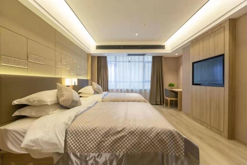 a hotel room with two beds and a flat screen tv at Morninginn, Chenzhou Guiyang in Guiyang