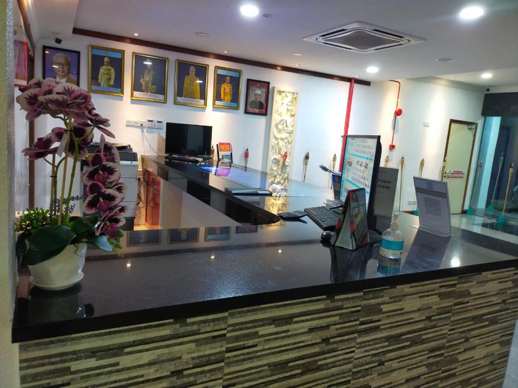 a lobby with a counter with flowers on it at Che Wok Hotel in Kota Bharu