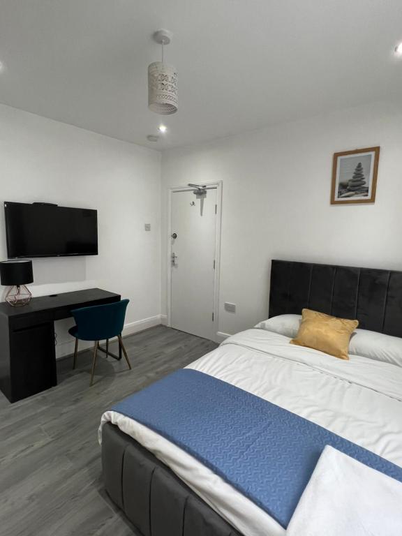 a bedroom with a bed and a desk and a television at En-suite double room in Wanstead