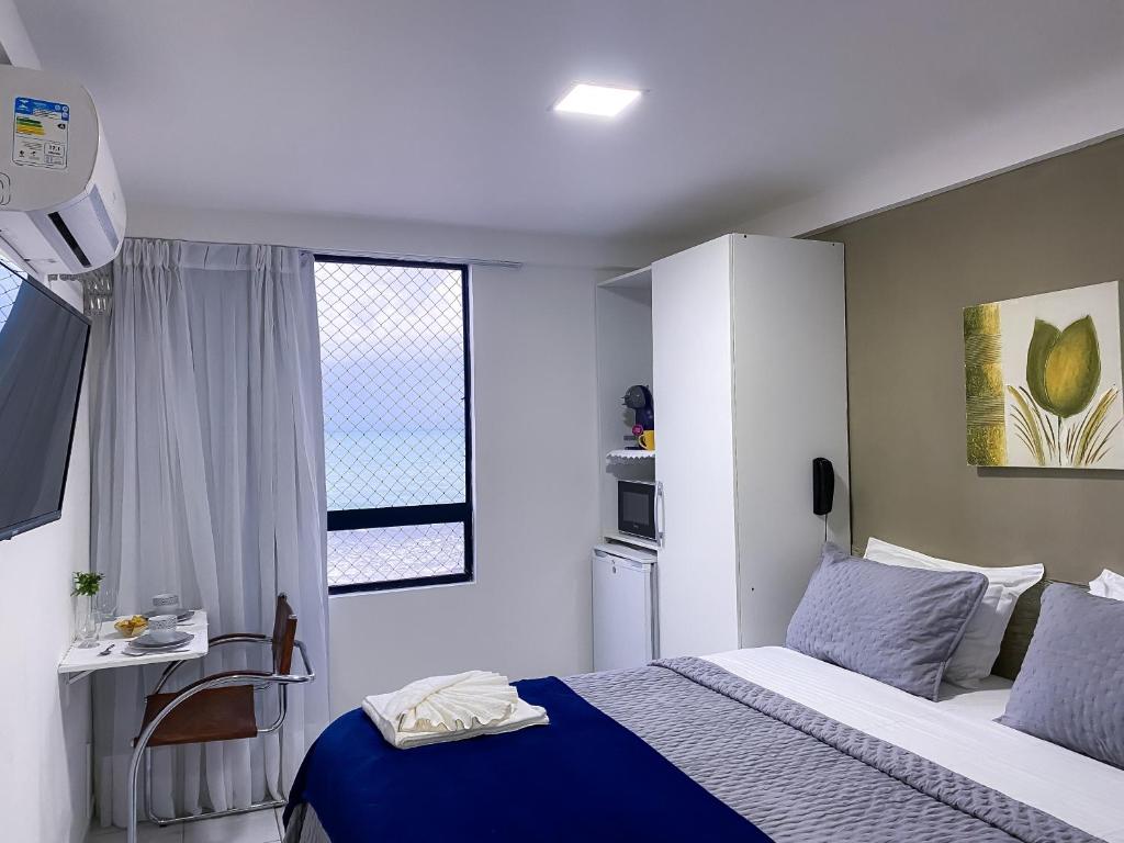 um pequeno quarto com uma cama e uma janela em Acomodação aconchegante à beira- mar em Natal