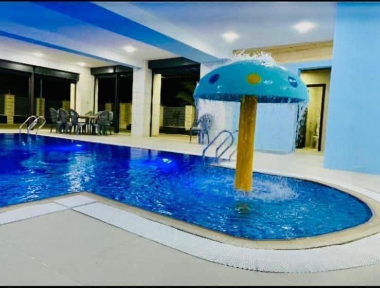 傑里科的住宿－villa wardet algabal，一座建筑中间的游泳池,有一个喷泉