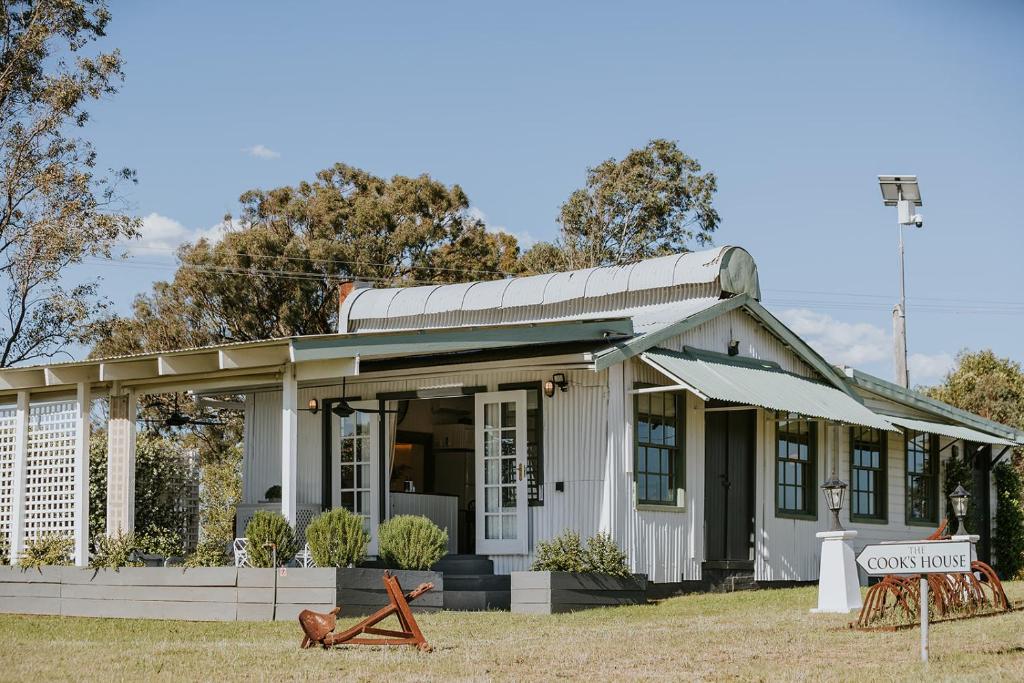 un piccolo edificio bianco con un cartello di fronte di The Cooks House at Corunna Station a Belford