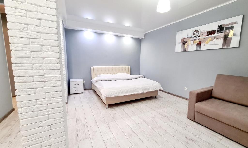 a bedroom with a bed and a chair in it at Apartaments on vulytsia Heroiv Ato 32 (97th Kvartal) in Kryvyi Rih