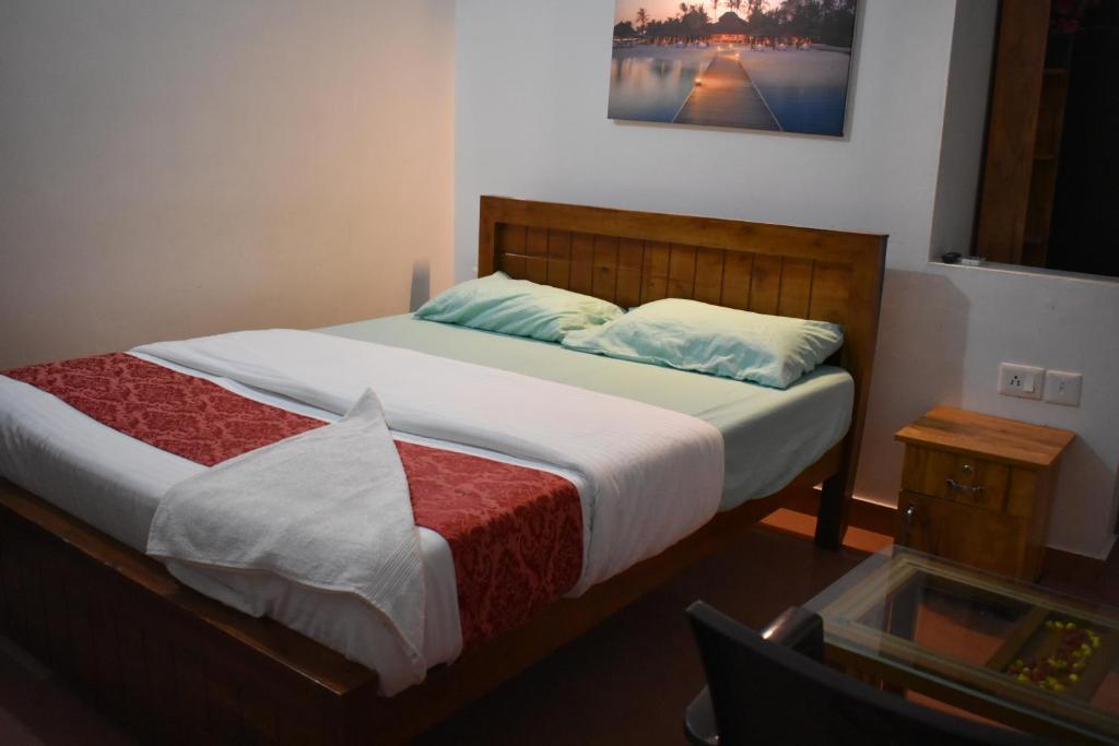 a bedroom with a large bed with a wooden headboard at Ben's Villa Kannur ! in Kannur